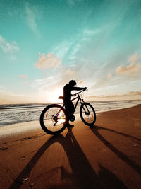 Man riding bicycle on beach