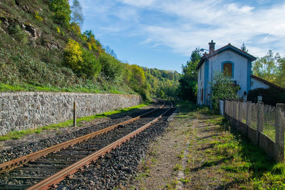 Railroad tracks by building against sky