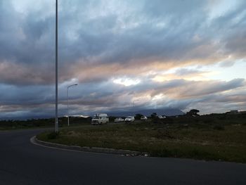 Street amidst field against sky