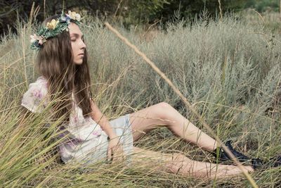 Young woman sitting on grassy field