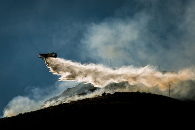 Low angle view of airplane flying against sky