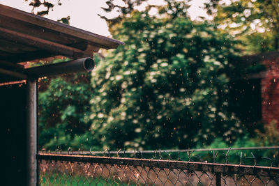 Water drops on metal railing against sky