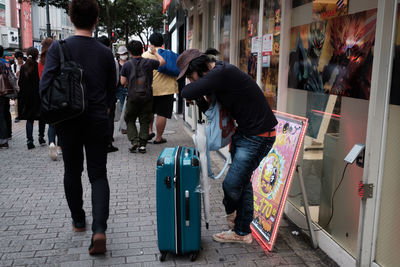 Rear view of people at store in city