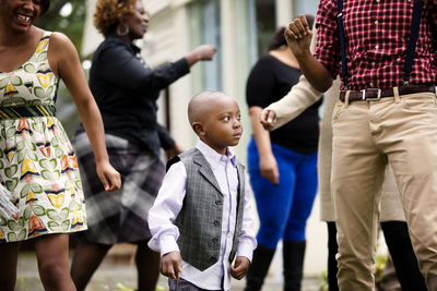 Boy dancing with family and friends in backyard