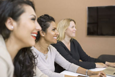 Side view of businesswomen sitting in meeting at creative office