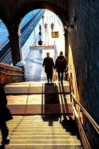 People walking on staircase in city