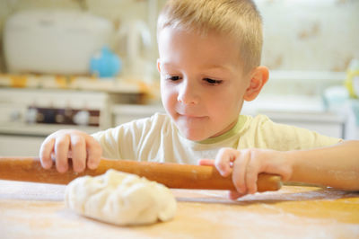 Close-up portrait of boy eating food on table