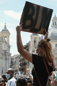 People on street in city against sky