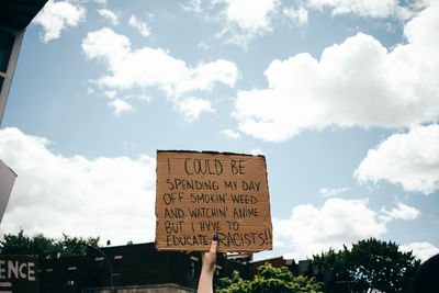 Low angle view of information sign against sky