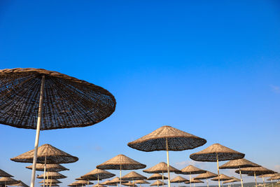 Umbrellas on beach against clear blue sky