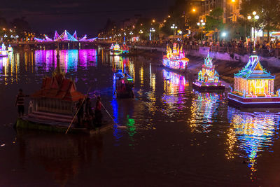 Illuminated buildings by river in city at night soc trang