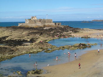 High angle view of people enjoying at beach against historic building