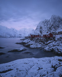 Scenic view of snow covered houses and mountains against sky