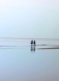 People on beach against sky