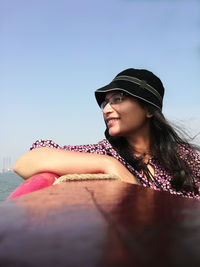 Smiling woman sitting in boat against clear sky