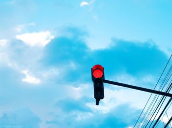 Low angle view of road signal against sky