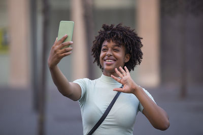  logger afro hair laughing, holding phone, recording vlog, shooting social media story or video call 