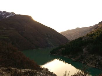 Scenic view of river and mountains against clear sky