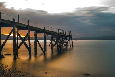 Pier on sea at sunset