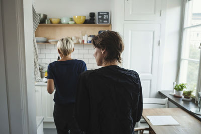 Rear view of product designers in kitchen at home