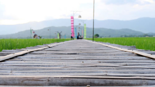 Surface level of empty road on field against sky