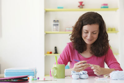 Woman sitting on table at home