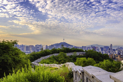 Buildings in city against cloudy sky