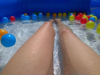 Low section of woman relaxing in swimming pool