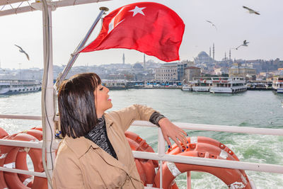 Woman sitting on boat against sea