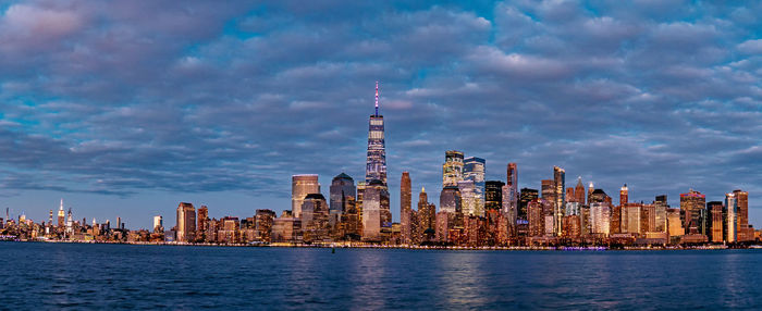 Panoramic view of buildings in city against cloudy sky