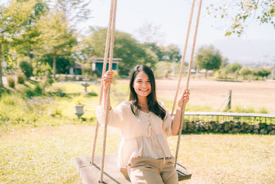 Young woman sitting on swing in playground
