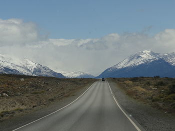 Road leading towards mountain against sky