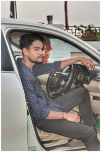Young man sitting on car