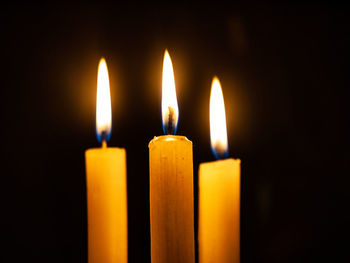 Close-up of candles burning in darkroom