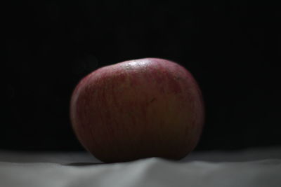 Close-up of apple on table against black background