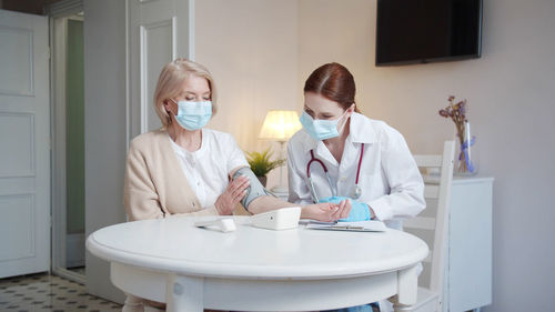 Doctor wearing mask examining patient