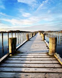 Wooden pier on footbridge against sky