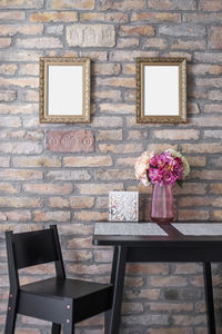 Flower vase on table against wall