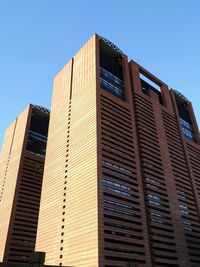 Low angle view of modern building against clear blue sky