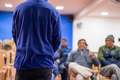 Rear view of people sitting in corridor