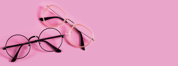 High angle view of eyeglasses against pink background