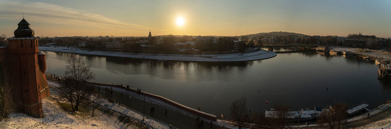 High angle view of river by buildings against sky during sunset