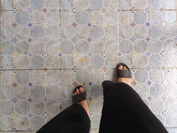 Low section of woman standing on tiled floor