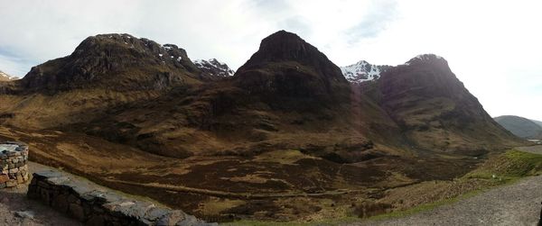 Scenic view of rocky mountains against cloudy sky