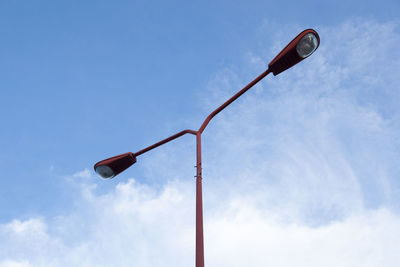 Low angle view of telephone pole against clear blue sky