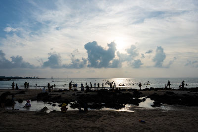 People on beach against sky