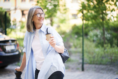 Portrait of smiling young woman standing in park