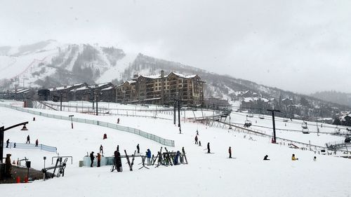 People on snow covered mountain against sky