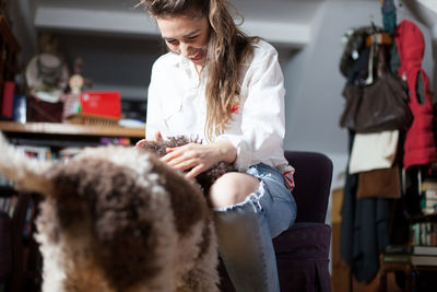 Woman stroking dog at home