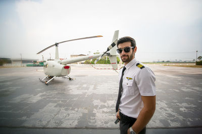 View of man standing on airport runway against sky